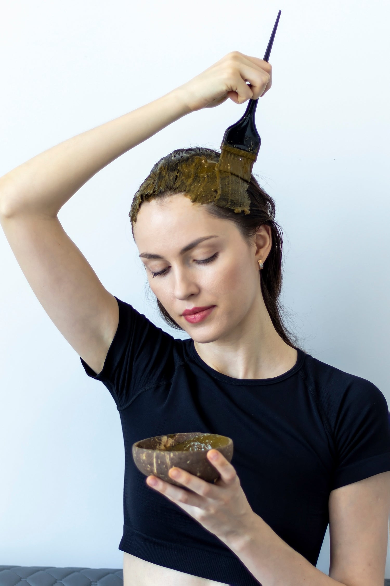 Frau trägt RELIQT Pflanzenhaarfarbe mit einem Pinsel auf – natürliche Haarfärbung mit pflanzlicher Farbe aus Naturkosmetik, schonend für Haar und Kopfhaut